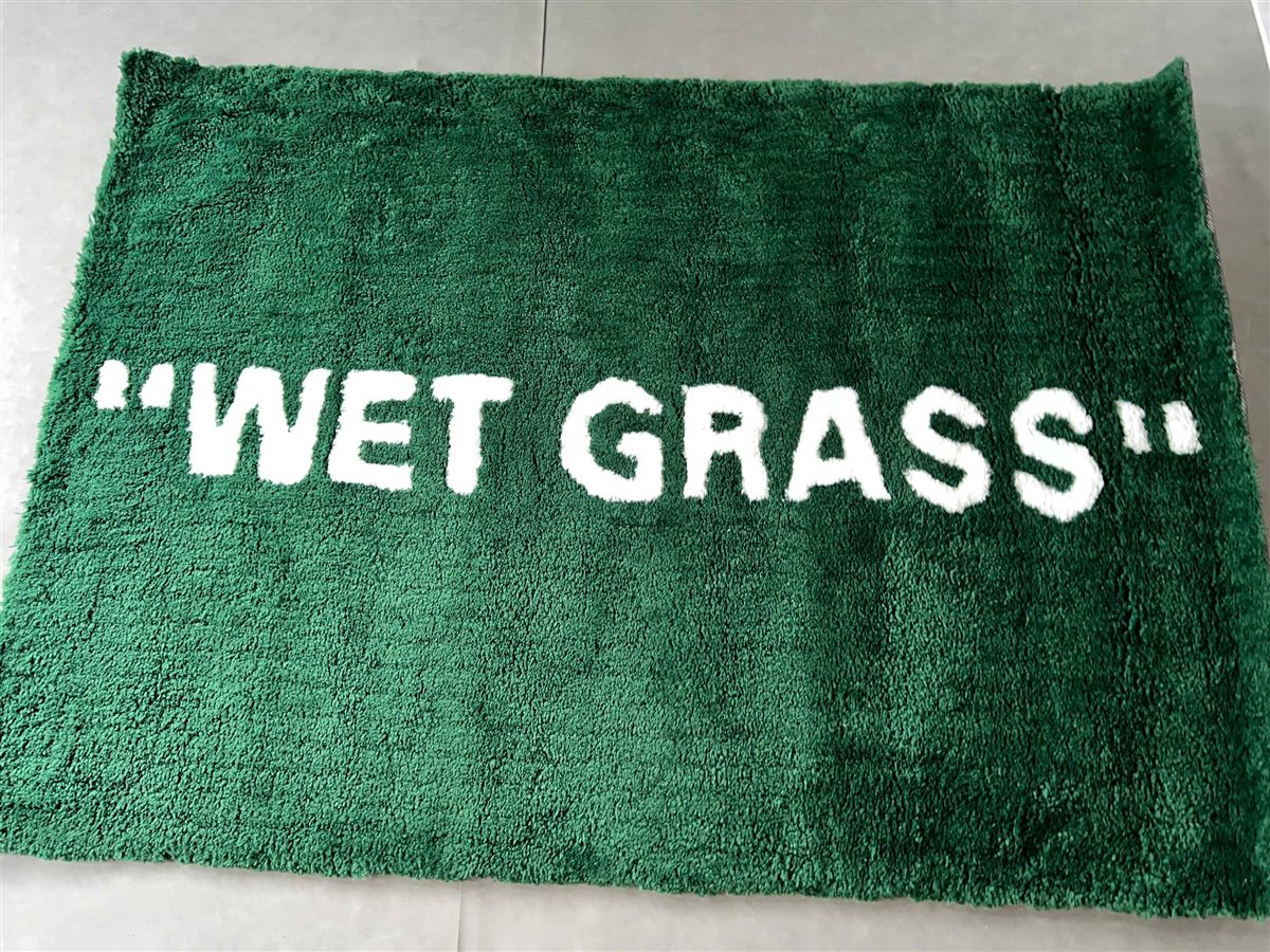 Cận bề mặt lông xanh và chữ WET GRASS trên thảm